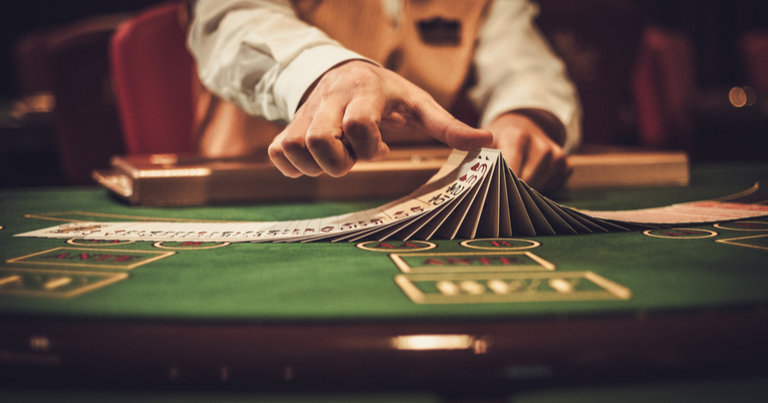 Un crupier manipulando cartas en una mesa de juego de un casino