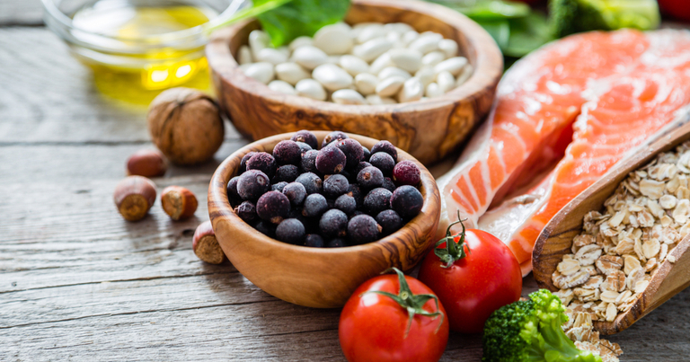 Verduras y proteínas saludables sobre una tabla de madera.