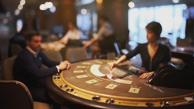 Imagen de una mesa de blackjack con un jugador y una crupier.