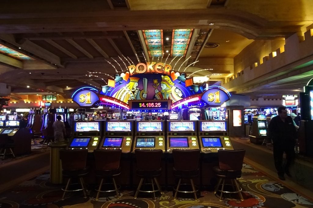 Bagian interior kasino dengan beberapa mesin slot berturut-turut.